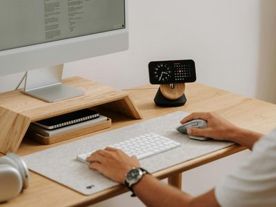 Clean minimalist office desk with a green plant.
